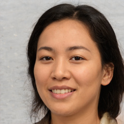 Joyful asian young-adult female with long  brown hair and brown eyes