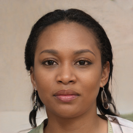 Joyful black young-adult female with long  black hair and brown eyes