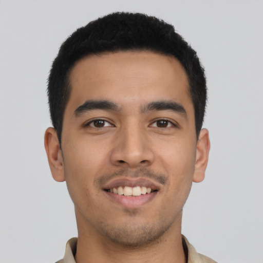 Joyful latino young-adult male with short  black hair and brown eyes
