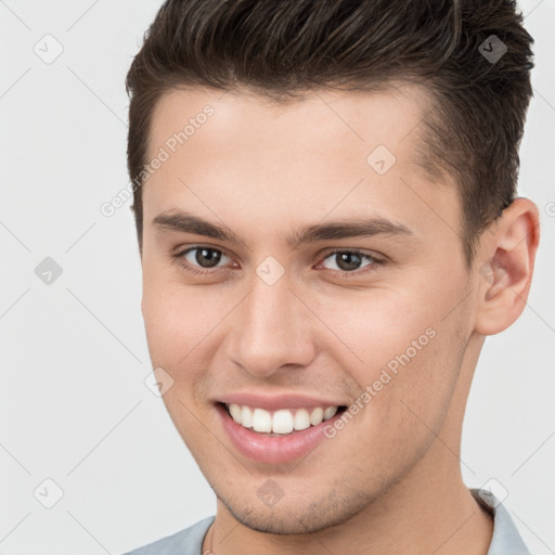 Joyful white young-adult male with short  brown hair and brown eyes