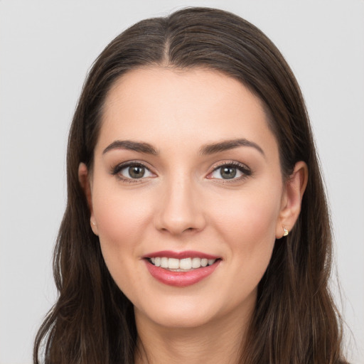 Joyful white young-adult female with long  brown hair and brown eyes