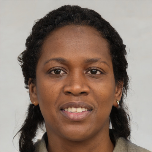 Joyful black young-adult female with long  black hair and brown eyes