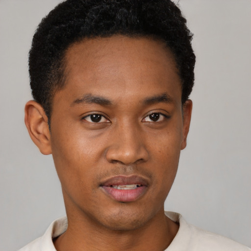 Joyful black young-adult male with short  black hair and brown eyes