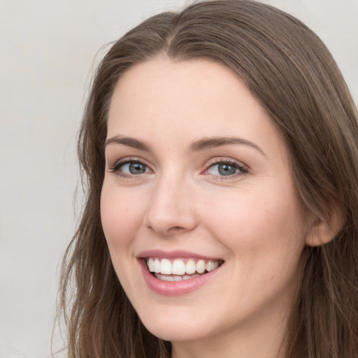 Joyful white young-adult female with long  brown hair and grey eyes