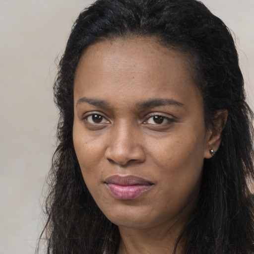 Joyful black young-adult female with long  brown hair and brown eyes
