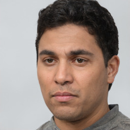 Joyful white young-adult male with short  black hair and brown eyes