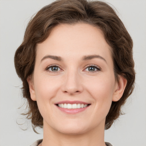 Joyful white young-adult female with medium  brown hair and green eyes