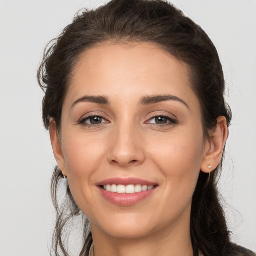 Joyful white young-adult female with long  brown hair and brown eyes