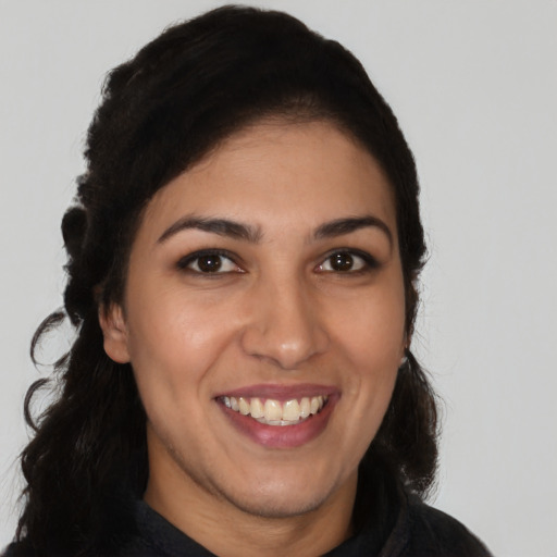 Joyful latino young-adult female with long  brown hair and brown eyes