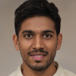 Joyful latino young-adult male with short  brown hair and brown eyes