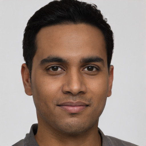 Joyful latino young-adult male with short  black hair and brown eyes