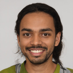 Joyful latino young-adult male with short  black hair and brown eyes