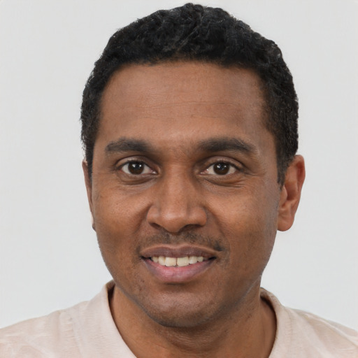 Joyful black adult male with short  black hair and brown eyes