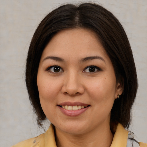Joyful latino young-adult female with medium  brown hair and brown eyes