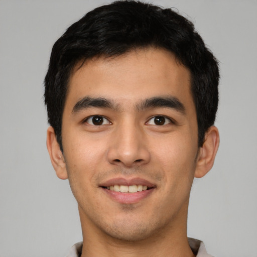 Joyful latino young-adult male with short  black hair and brown eyes