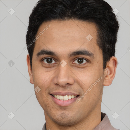 Joyful latino young-adult male with short  brown hair and brown eyes