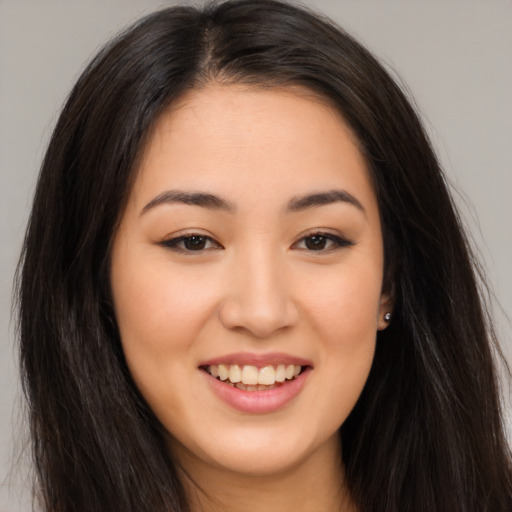 Joyful asian young-adult female with long  brown hair and brown eyes