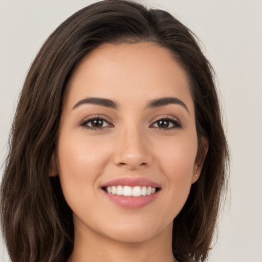 Joyful white young-adult female with long  brown hair and brown eyes