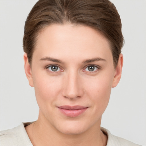 Joyful white young-adult female with short  brown hair and grey eyes