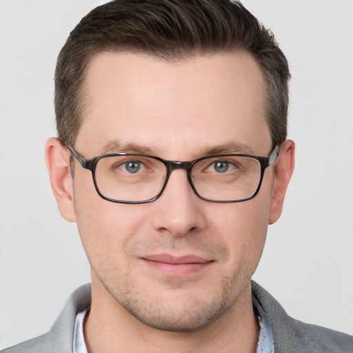 Joyful white young-adult male with short  brown hair and grey eyes