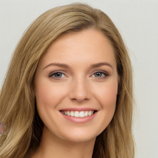 Joyful white young-adult female with long  brown hair and green eyes