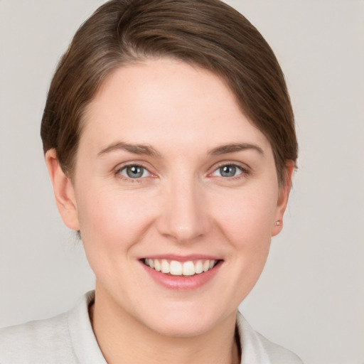 Joyful white young-adult female with medium  brown hair and grey eyes