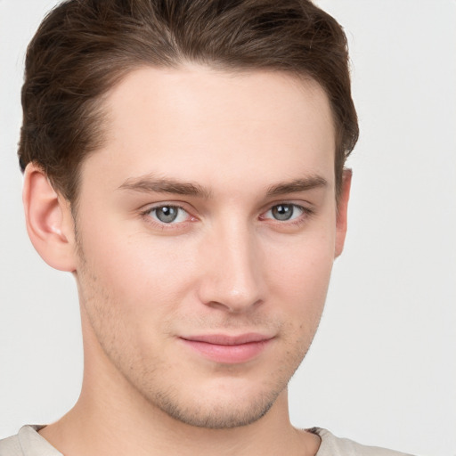 Joyful white young-adult male with short  brown hair and grey eyes