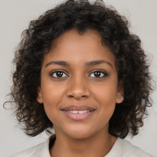 Joyful black young-adult female with medium  brown hair and brown eyes
