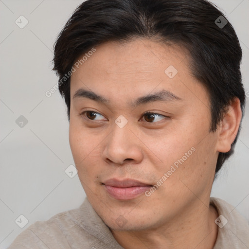 Joyful asian young-adult male with short  brown hair and brown eyes