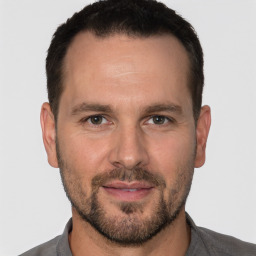 Joyful white adult male with short  brown hair and brown eyes