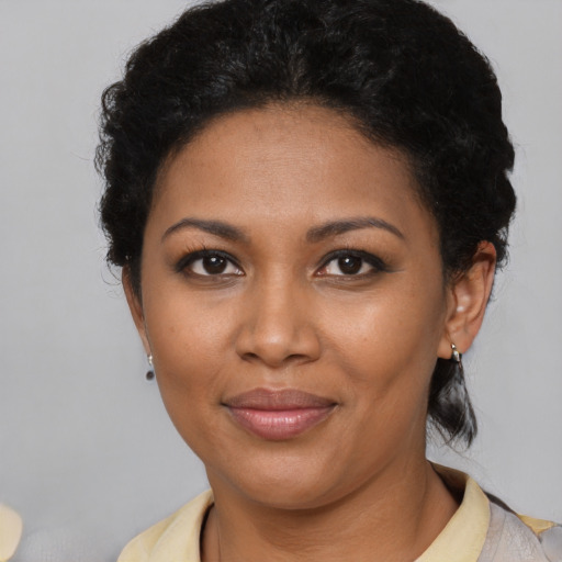 Joyful black young-adult female with short  brown hair and brown eyes