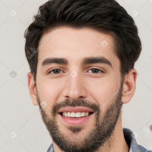 Joyful white young-adult male with short  black hair and brown eyes