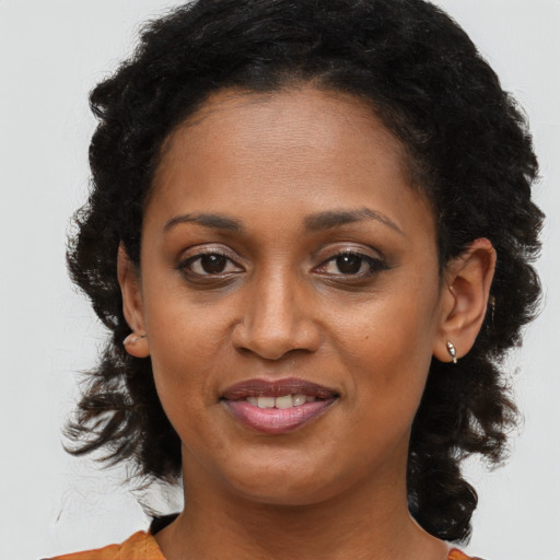 Joyful black adult female with medium  brown hair and brown eyes