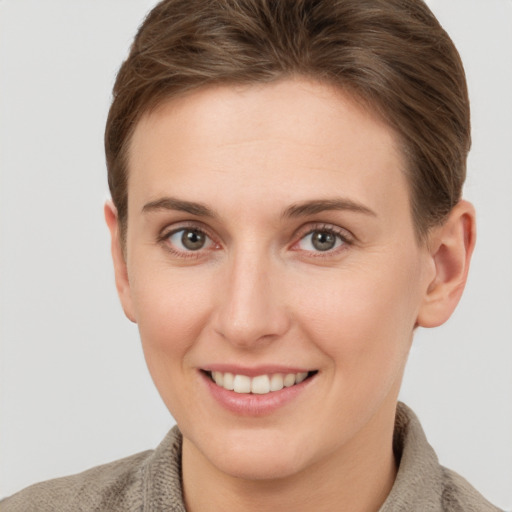 Joyful white young-adult female with short  brown hair and grey eyes