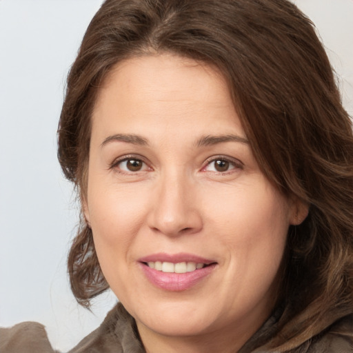 Joyful white adult female with medium  brown hair and brown eyes