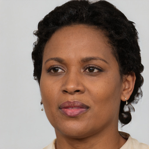Joyful black adult female with short  black hair and brown eyes