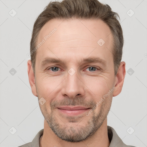 Joyful white adult male with short  brown hair and grey eyes