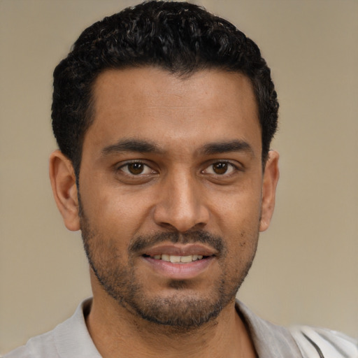 Joyful black young-adult male with short  black hair and brown eyes