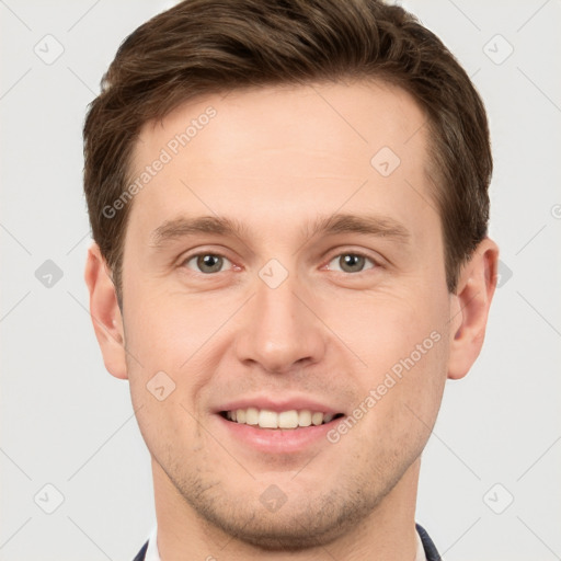 Joyful white young-adult male with short  brown hair and grey eyes