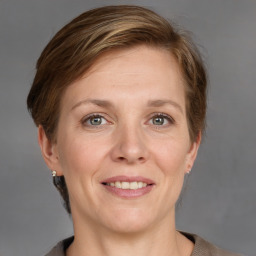 Joyful white adult female with medium  brown hair and grey eyes