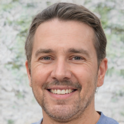 Joyful white adult male with short  brown hair and brown eyes