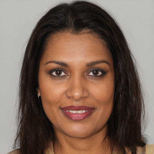 Joyful black young-adult female with long  brown hair and brown eyes