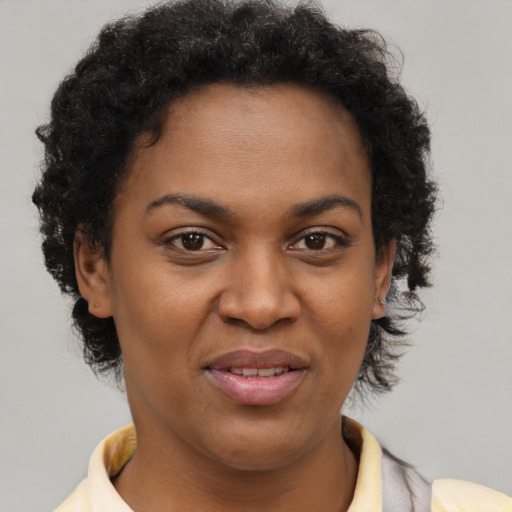 Joyful black young-adult female with short  brown hair and brown eyes