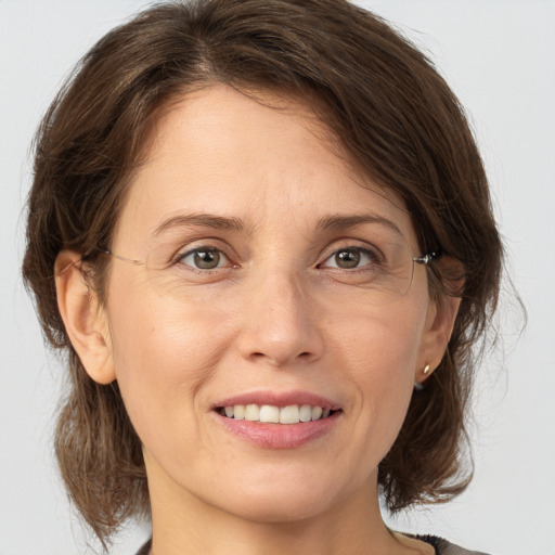 Joyful white adult female with medium  brown hair and grey eyes