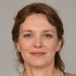 Joyful white adult female with medium  brown hair and blue eyes