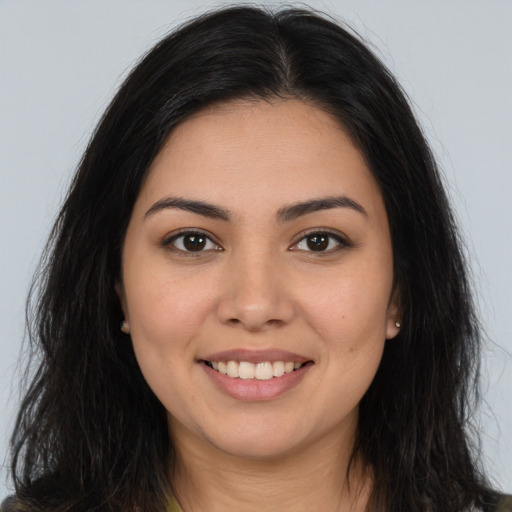 Joyful latino young-adult female with long  brown hair and brown eyes