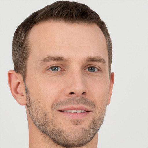 Joyful white young-adult male with short  brown hair and grey eyes