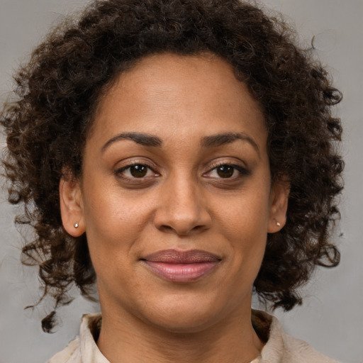 Joyful black young-adult female with medium  brown hair and brown eyes