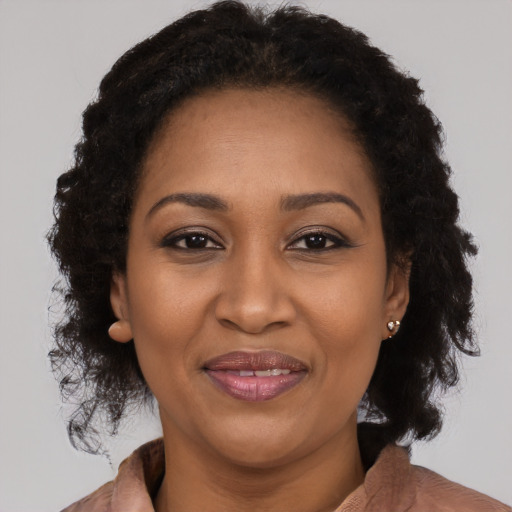 Joyful black adult female with long  brown hair and brown eyes