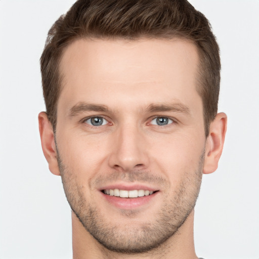 Joyful white young-adult male with short  brown hair and grey eyes